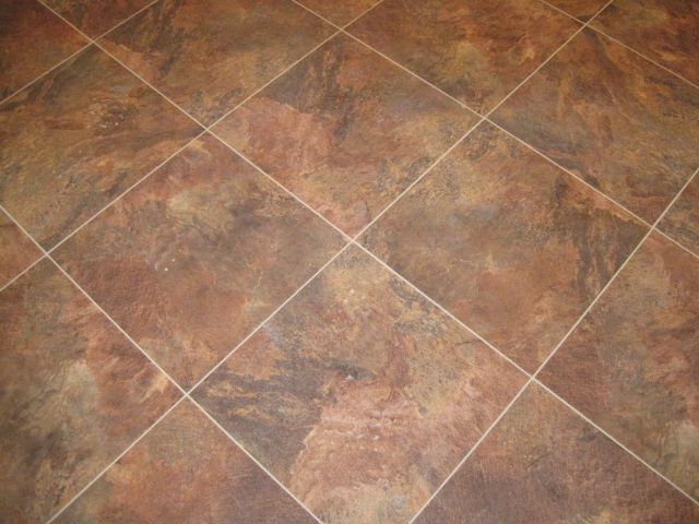 The kitchen flooring, a large vinyl tile with stone powder embedded.